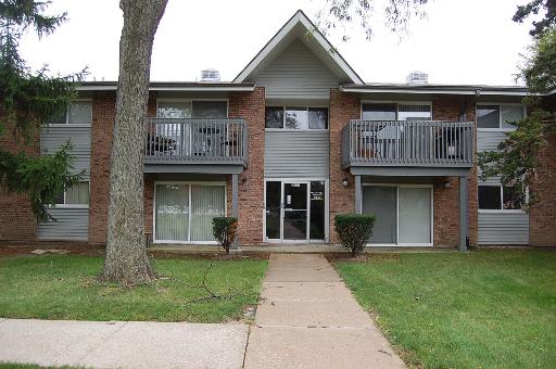 Front view of a two-story building with balconies and brick exterior.