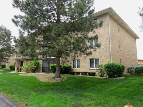 Front view of a multi-story brick apartment building.