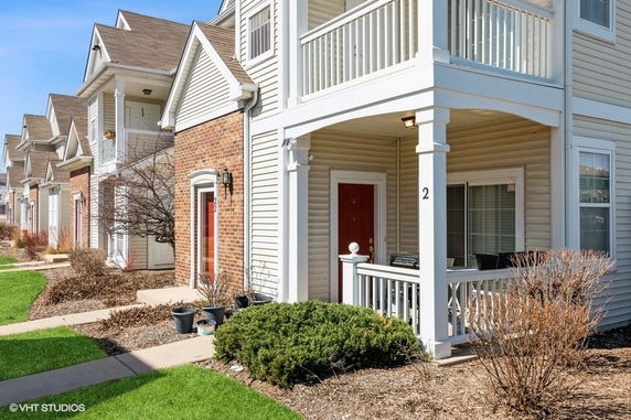Front view of townhouses with brick and siding exteriors and covered porches.
