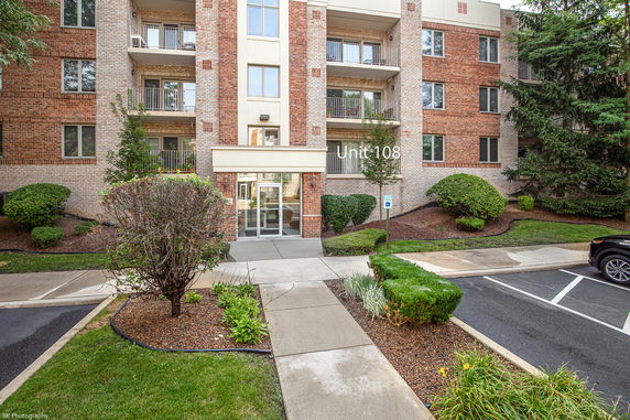Front view of an apartment building with balconies and a main entrance.