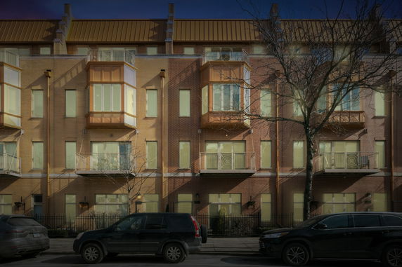Front view of a multi-story brick building with balconies.