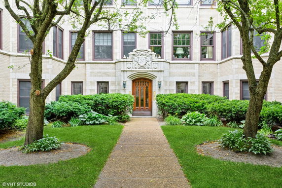Front view of a multi-story residential building with decorative entrance.