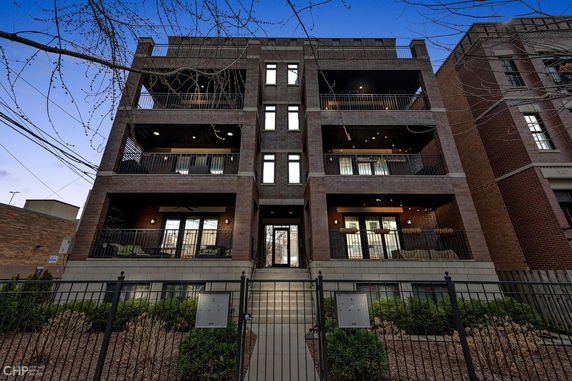 Front view of a multi-story brick building with balconies.