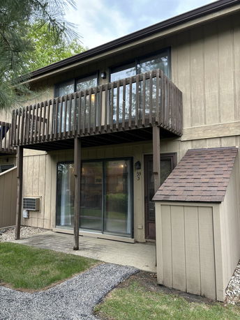 Front view of a two-story house with a wooden balcony.