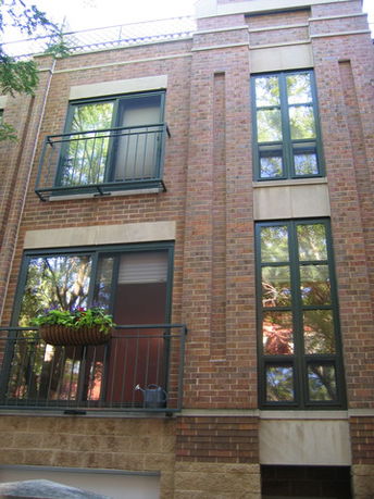 Front view of a multi-story building with brick facade and large windows.