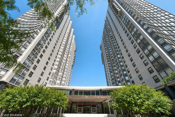 Front view of tall twin apartment buildings with multiple windows.