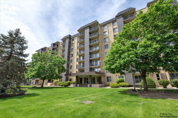 Front view of a multi-story apartment building with balconies.