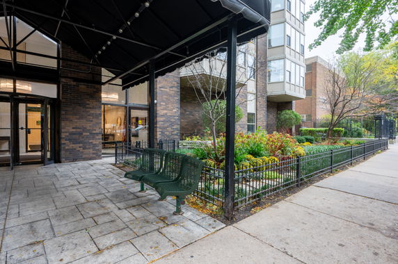 Front view of a building entrance with glass doors and a canopy.