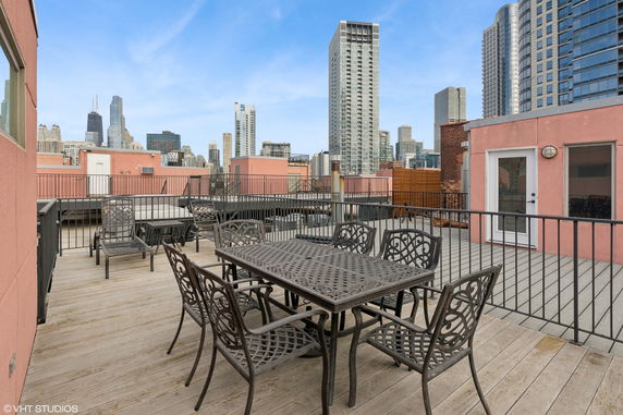 Rooftop with seating arrangements and a view of city skyscrapers.