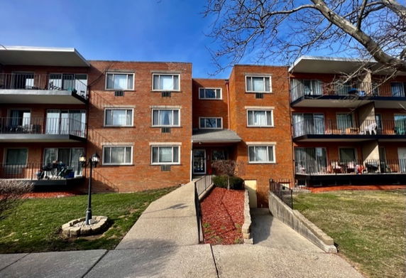 Front view of a three-story residential building with balconies.
