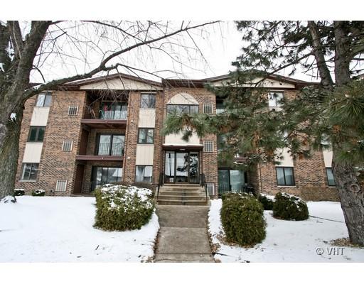Front view of a multi-story brick apartment building with balconies.