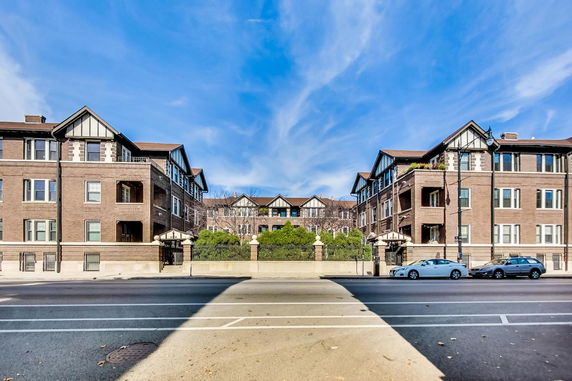 Front view of a multi-story brick building complex with gabled roofs.