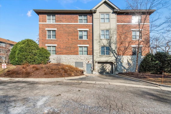 Front view of a multi-story brick building with a concrete base.