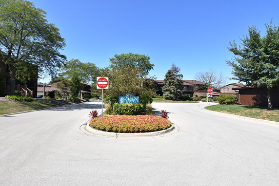 Entrance to a residential area with a 'Do Not Enter' sign and landscaped median.