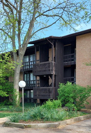 Front view of a multi-story building with wooden balconies.