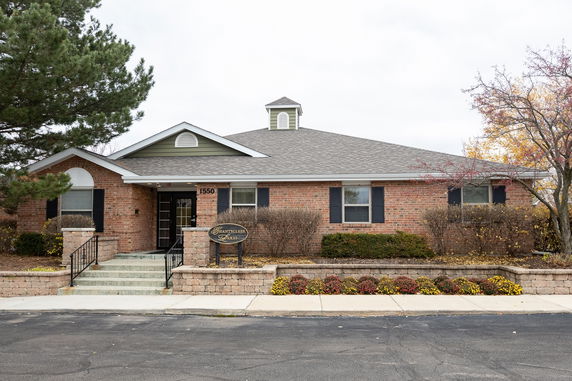 Front view of a single-story brick building with a pitched roof and entrance steps.