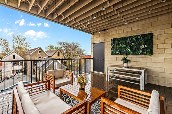 Rooftop area with seating, wall decor, and outdoor furniture.