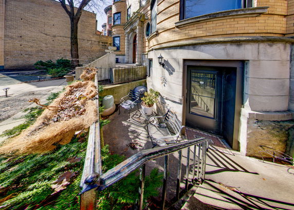 Front view of a multi-story building with brick exterior and a basement entrance.
