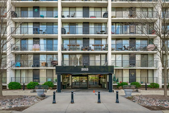 Front view of a multi-story apartment building with balconies.