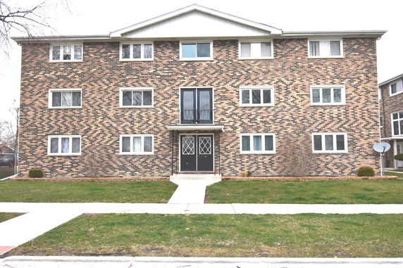 Front view of a three-story brick building with multiple windows and a central entrance.