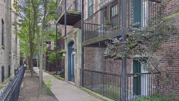 Front view of a multi-story brick building with balconies.