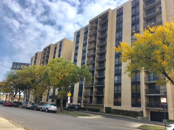 Front view of a multi-story apartment building with balconies.