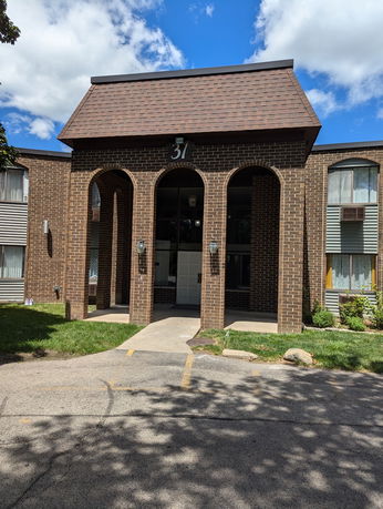Front elevation of a brick building with an arched entrance.