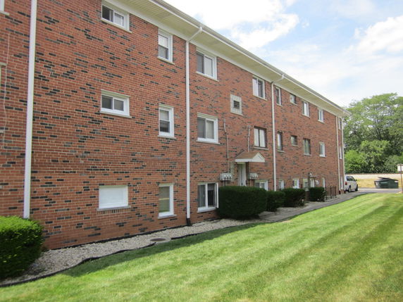 Front view of a three-story brick apartment building.