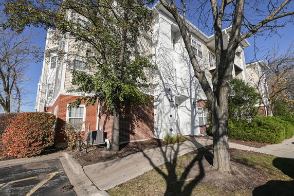 Front view of a multi-story residential building with brick and siding exterior.