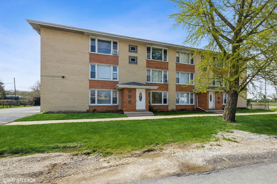 Front view of a three-story residential building with brick facade.