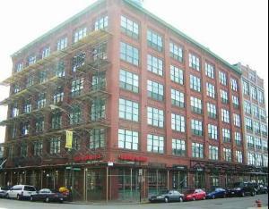 Front view of a multi-story brick building with large windows.