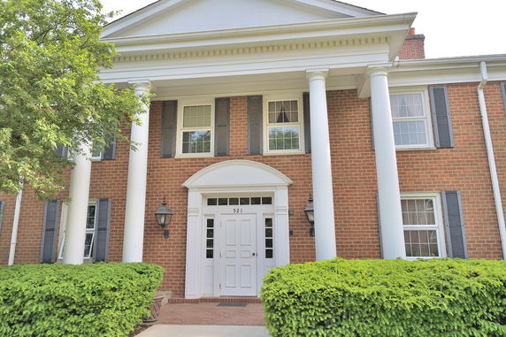 Front view of a two-story house with brick exterior and white columns.