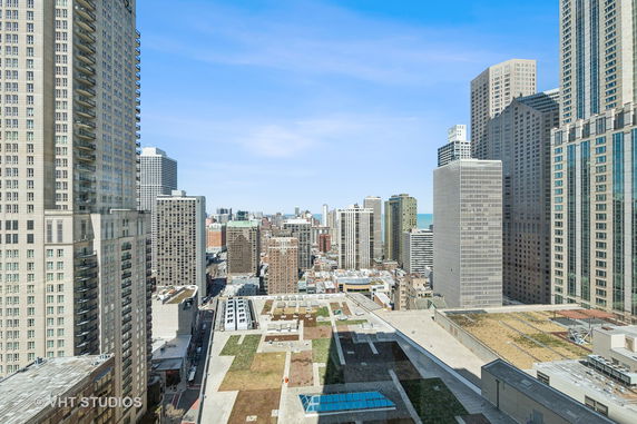 Panoramic view of a cityscape with multiple tall buildings and a clear blue sky.