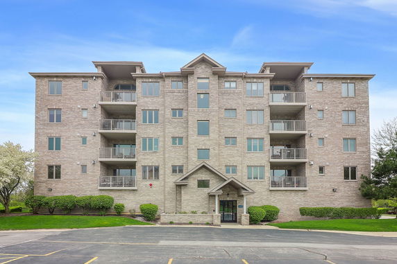 Front view of a multi-story apartment building with balconies.
