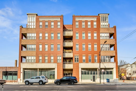 Front view of a multi-story brick building with large windows and a central entrance.