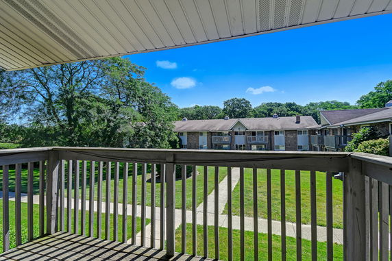 Balcony view of a residential complex with a grassy courtyard.