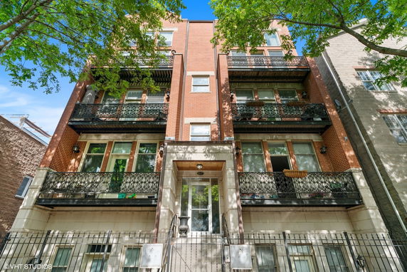 Front view of a multi-story brick building with balconies.
