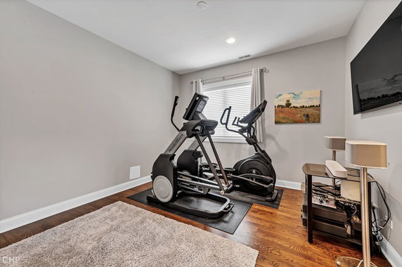 Indoor gym area with exercise machines and a TV on the wall.