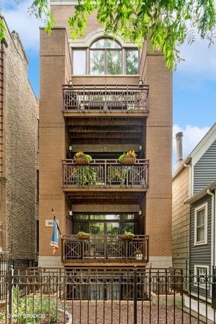 Front view of a multi-story brick building with balconies.
