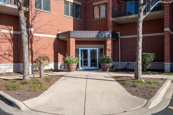 Front view of a brick building entrance with glass doors.