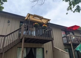Front view of a two-story building with balconies and a canopy.