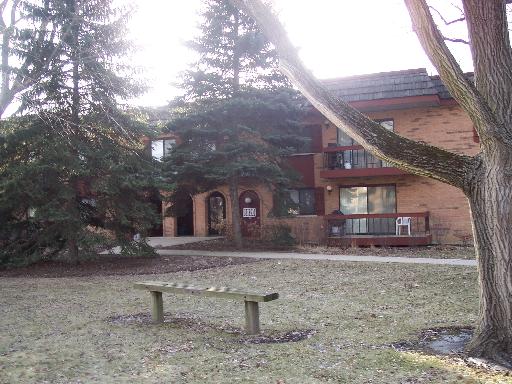 Front view of a multi-story brick building with balconies and a main entrance.