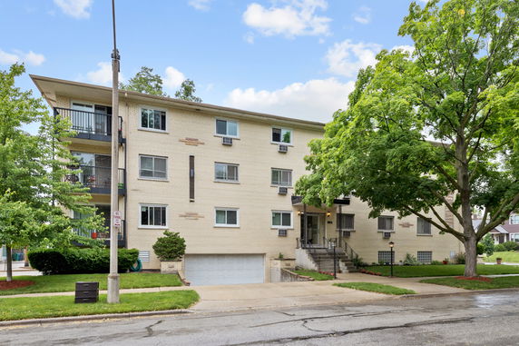 Front view of a multi-story apartment building with a garage entrance.