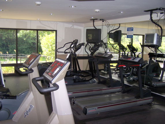 Interior view of a gym area with multiple treadmills and exercise equipment.