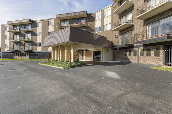 Front view of a multi-story apartment building with balconies.