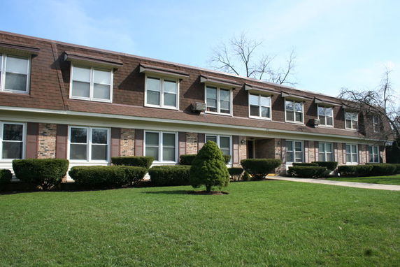 Front view of a two-story apartment building with brick and wood siding.