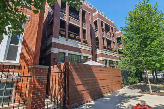 Front view of a multi-story brick building with balconies.