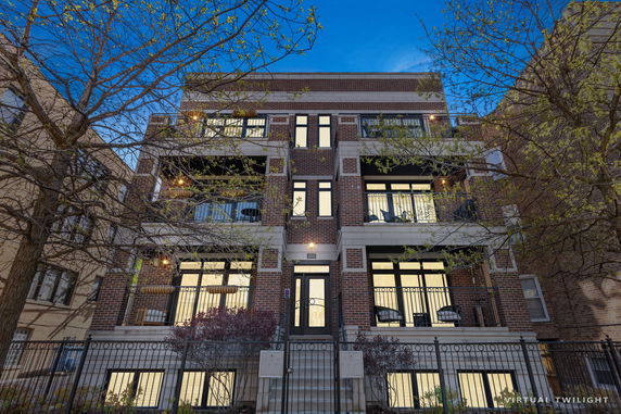 Front view of a multistory building with balconies and brick exterior.