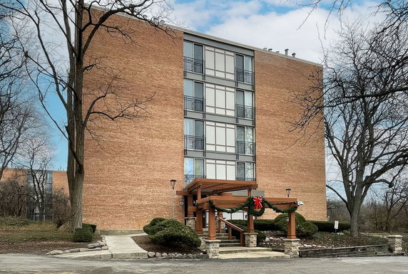 Front view of a multi-story brick building with a decorated entrance.