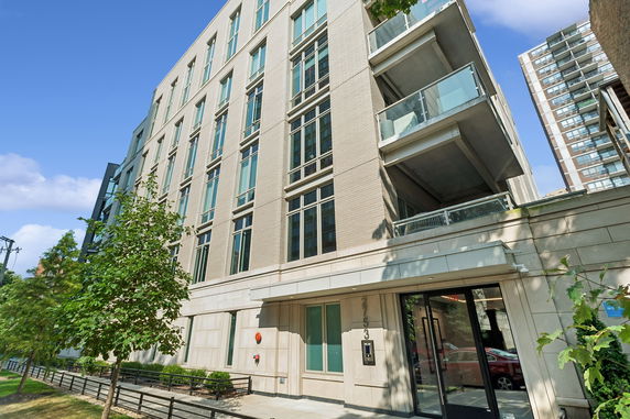 Front view of a modern multi-story building with large windows and balconies.